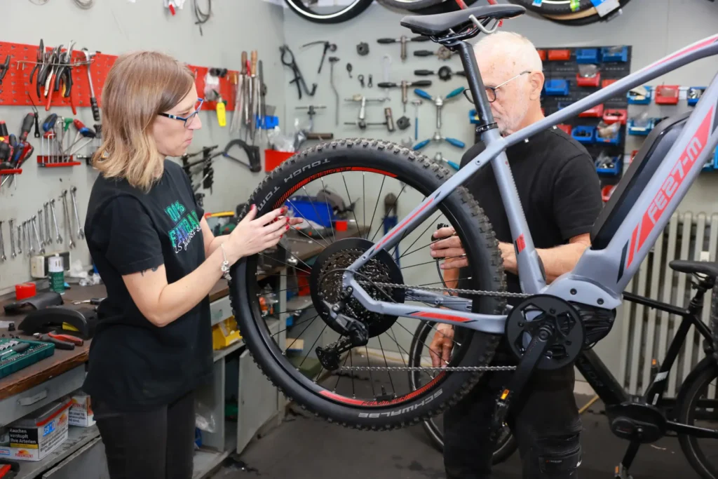 Zwei Mitarbeitende von Zweirad Romanski arbeiten an einem E-Mountainbike