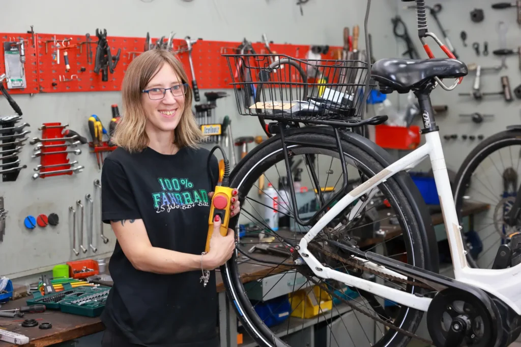 Mitarbeiterin zeigt ein weißes Trekkingrad im Verkaufsraum